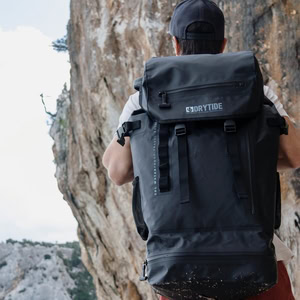 Home 8 DryTide waterproof backpack on hiker in outdoor mountain setting.