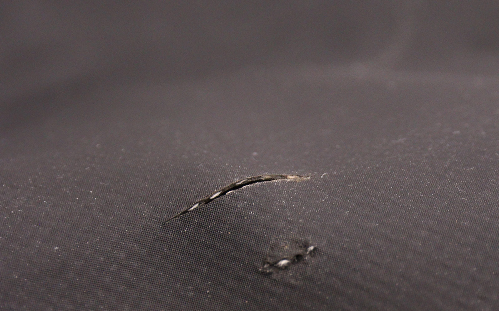 A small tear and a puncture in waterproof fabric