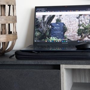 Laptop with laptop sleeve on living room shelf
