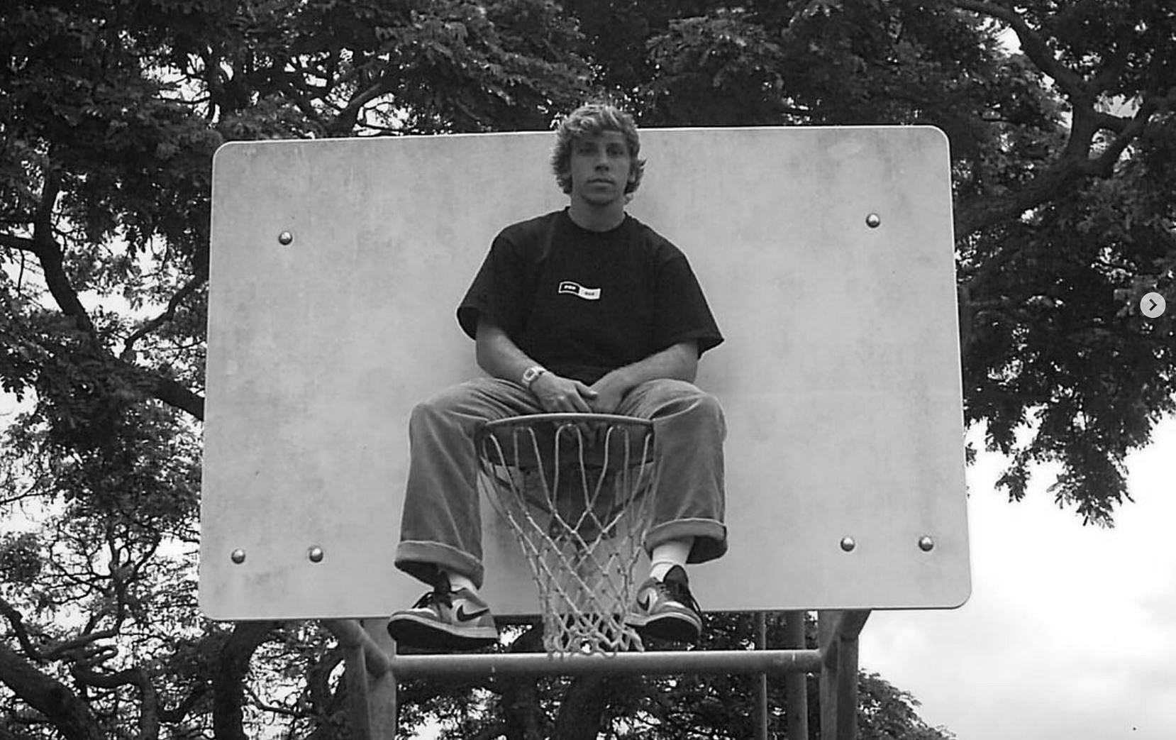 Reagan Popoff sitting on a basketball hoop